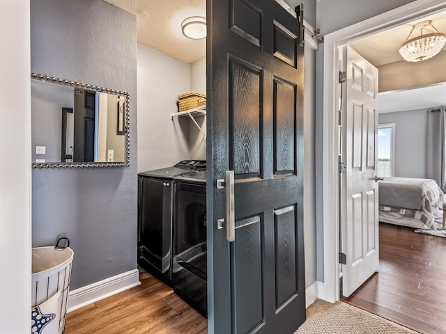 bathroom featuring washer and dryer, wood-type flooring, and a chandelier