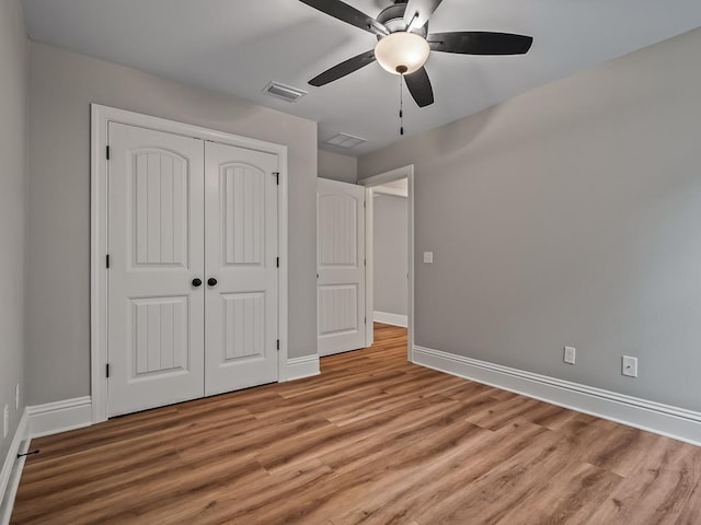 unfurnished bedroom with baseboards, visible vents, a ceiling fan, light wood-type flooring, and a closet