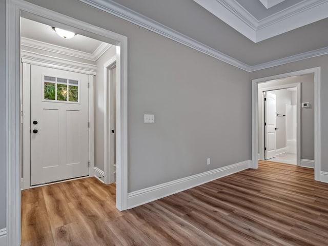 entryway featuring baseboards, wood finished floors, and crown molding