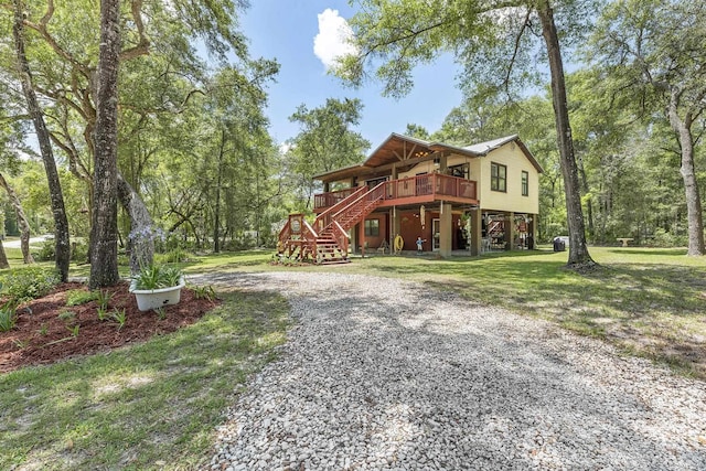 view of front facade with a wooden deck and a front lawn