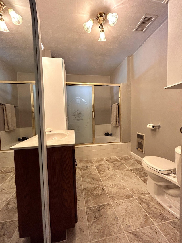 bathroom with heating unit, vanity, a textured ceiling, toilet, and walk in shower