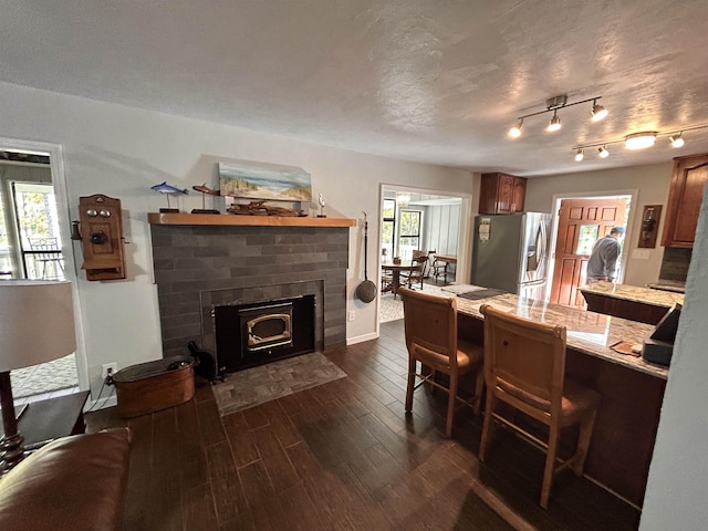 dining room with track lighting, dark hardwood / wood-style flooring, and a textured ceiling