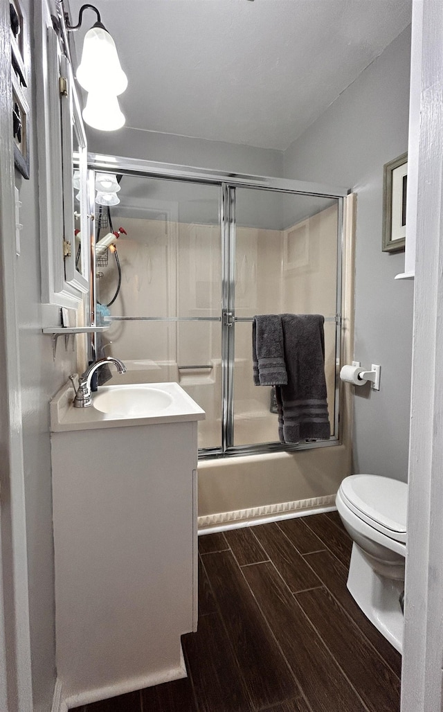 full bathroom featuring vanity, shower / bath combination with glass door, and toilet