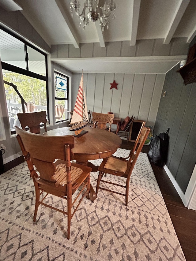 dining room featuring an inviting chandelier, dark hardwood / wood-style floors, and beamed ceiling