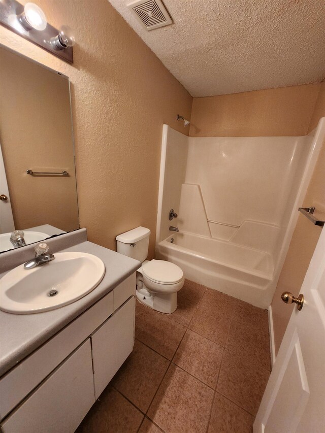 1100 Green Tree Ct Unit C, Tallahassee, FL 32304 - bathroom featuring a textured ceiling, a textured wall, vanity, toilet, and tile patterned flooring