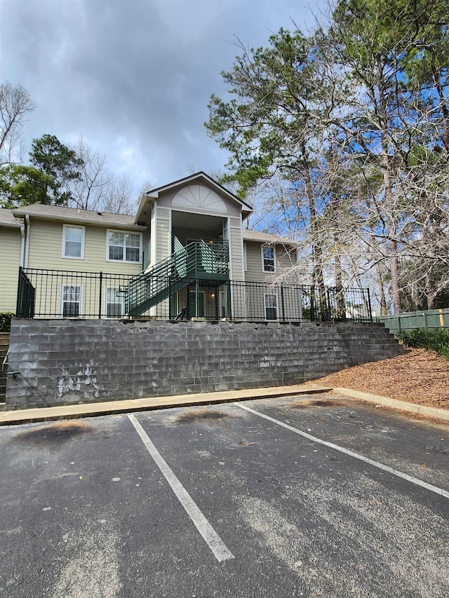 1100 Green Tree Ct Unit C, Tallahassee, FL 32304 - view of building exterior featuring stairs, uncovered parking, and fence