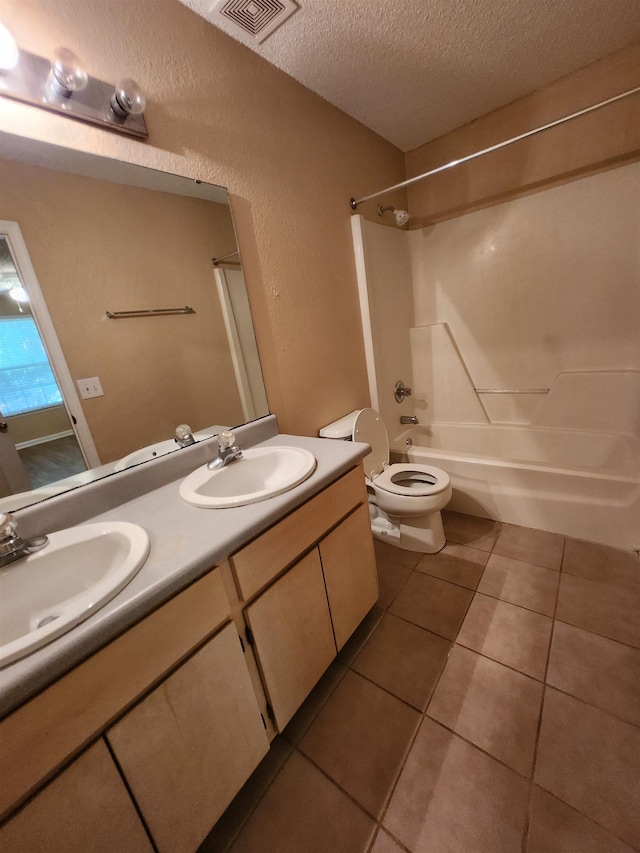 1100 Green Tree Ct Unit C, Tallahassee, FL 32304 - bathroom with tile patterned floors, a textured ceiling, toilet, double vanity, and shower / washtub combination