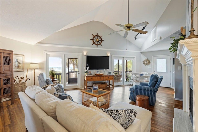 living area featuring ceiling fan, a fireplace, high vaulted ceiling, wood finished floors, and visible vents
