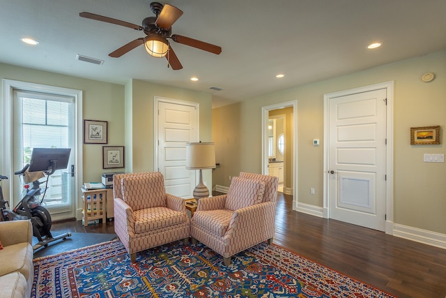 living area with dark hardwood / wood-style flooring and ceiling fan