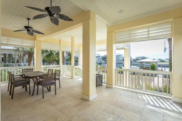 sunroom / solarium featuring wood ceiling and a water view