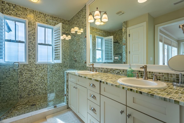 bathroom featuring vanity, plenty of natural light, backsplash, and walk in shower