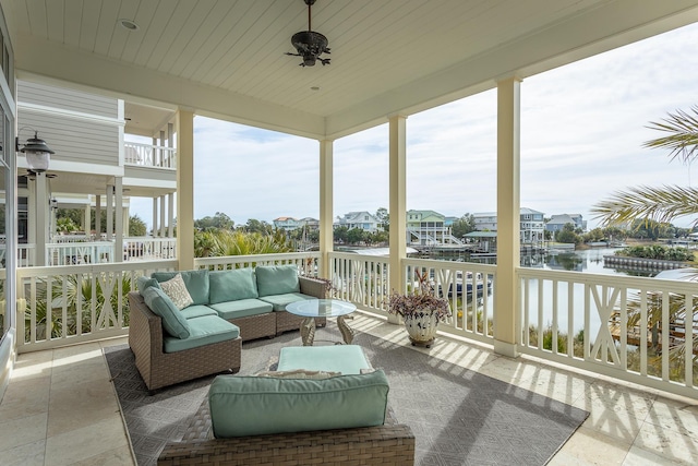 sunroom / solarium with wooden ceiling, ceiling fan, and a water view