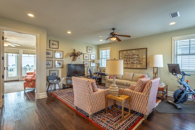 living room with dark wood-type flooring and ceiling fan