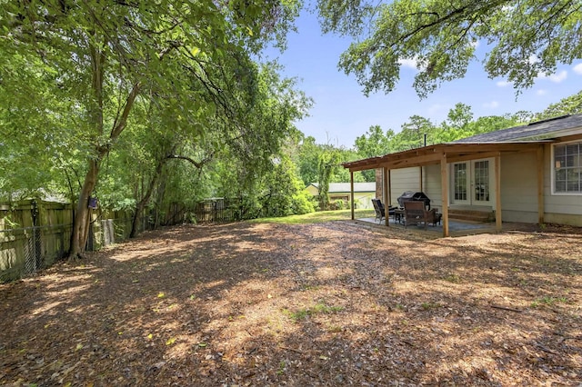 1816 Aaron Rd, Tallahassee, FL 32303 - fenced backyard featuring french doors, an attached garage, a patio area, and driveway
