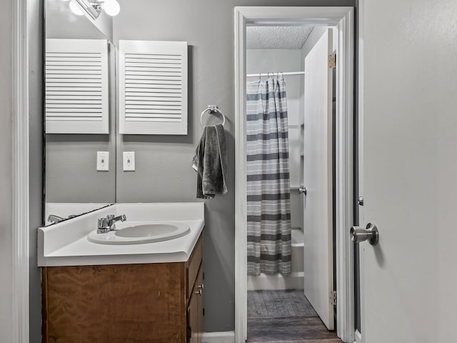 bathroom with shower / bath combo, wood finished floors, and vanity