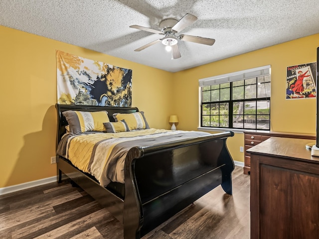 bedroom featuring baseboards, wood finished floors, a ceiling fan, and a textured ceiling