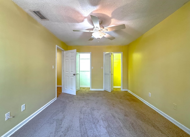 unfurnished bedroom with carpet, a textured ceiling, and ceiling fan