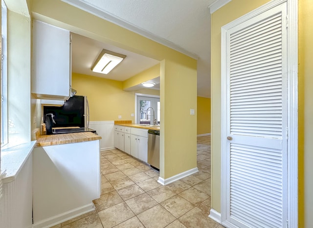 kitchen with refrigerator, sink, dishwasher, white cabinets, and light tile patterned flooring