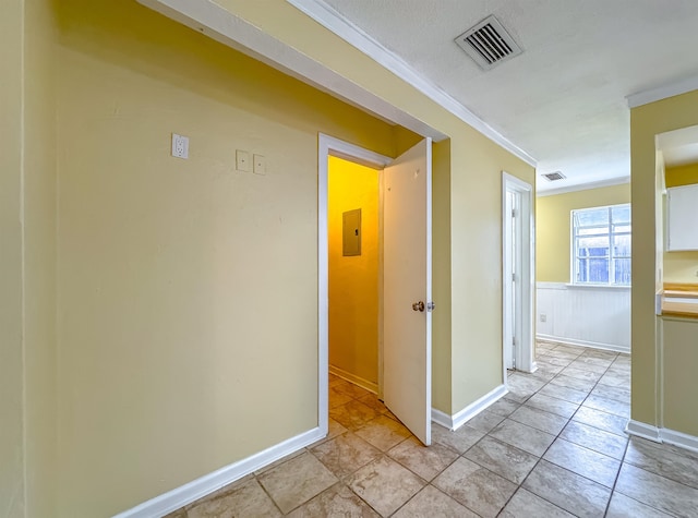 hall featuring light tile patterned floors and ornamental molding