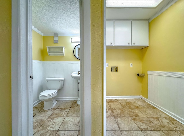 bathroom featuring crown molding, a textured ceiling, and toilet