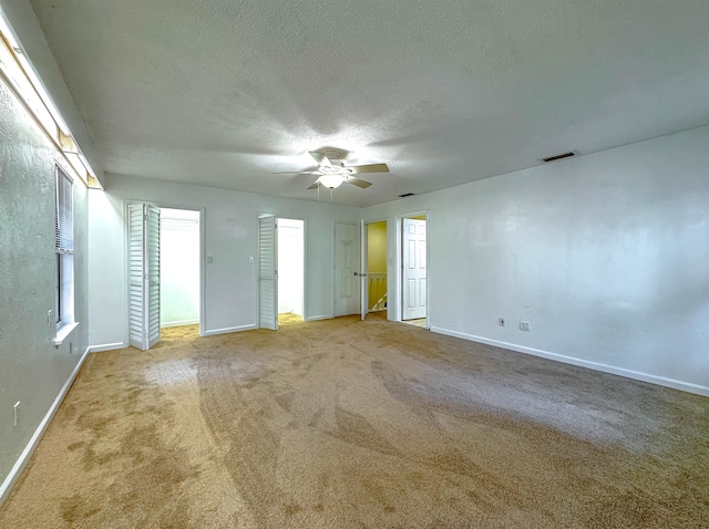 empty room with carpet, a textured ceiling, and ceiling fan