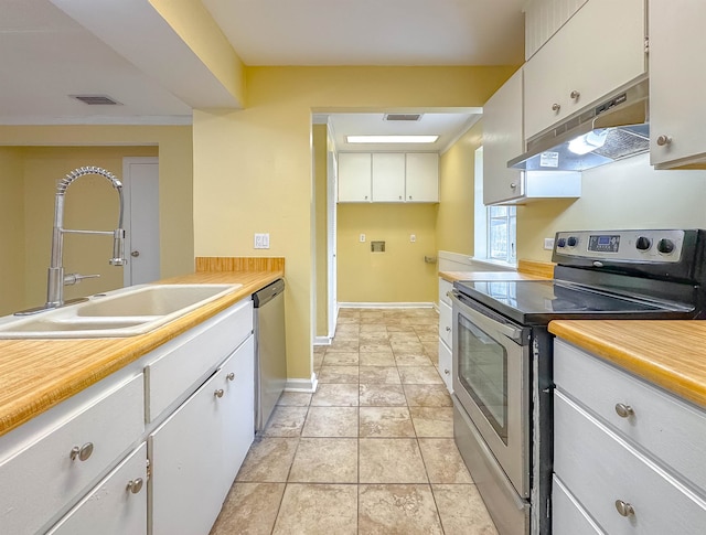 kitchen featuring sink, white cabinetry, stainless steel appliances, and light tile patterned floors