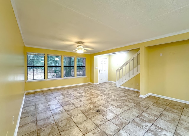 spare room featuring ceiling fan, ornamental molding, and a textured ceiling