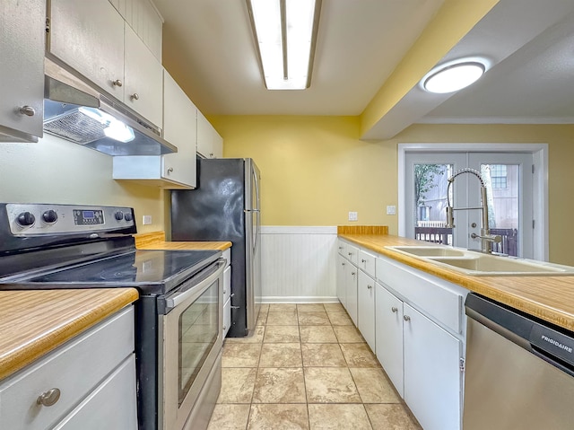 kitchen with appliances with stainless steel finishes, white cabinetry, ornamental molding, and sink