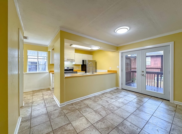 kitchen featuring a textured ceiling, crown molding, stainless steel appliances, and french doors