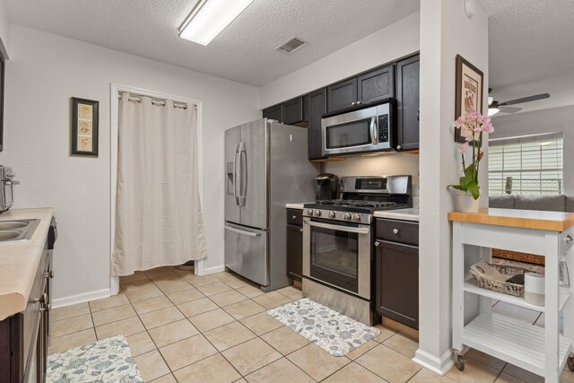 kitchen with appliances with stainless steel finishes, ceiling fan, light countertops, and visible vents