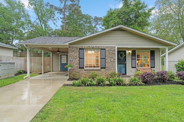 view of front facade featuring a shingled roof, fence, concrete driveway, a front lawn, and an attached carport