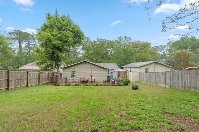 view of yard with a fire pit and a fenced backyard