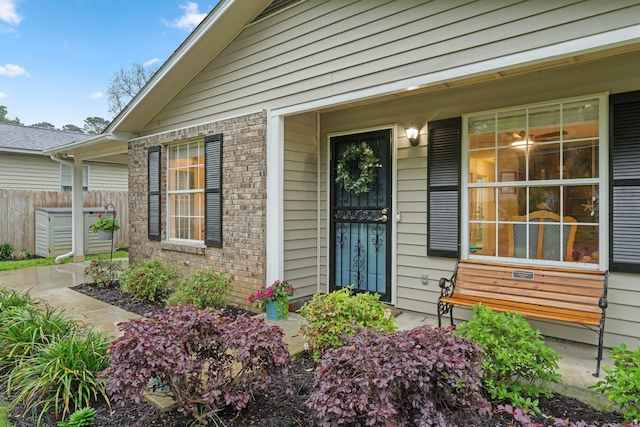 entrance to property with brick siding and fence