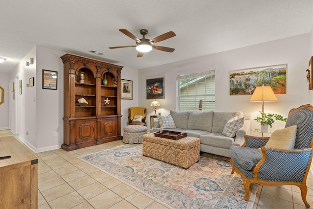 living area with baseboards, light tile patterned floors, a textured ceiling, a ceiling fan, and visible vents
