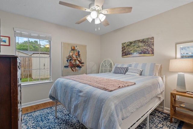 bedroom featuring wood finished floors, ceiling fan, and baseboards