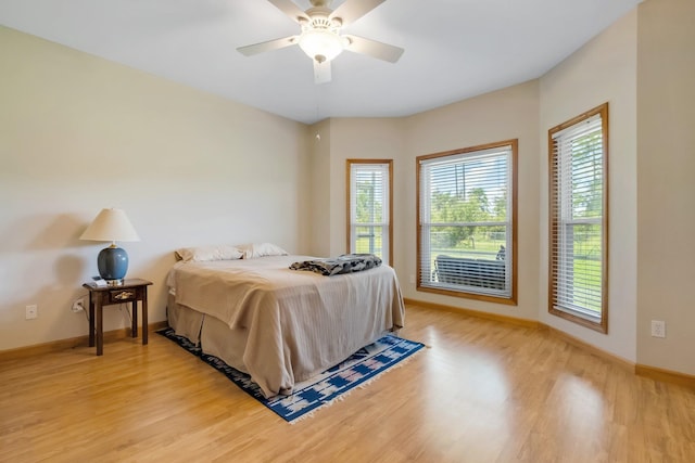 bedroom featuring light wood finished floors, baseboards, and a ceiling fan