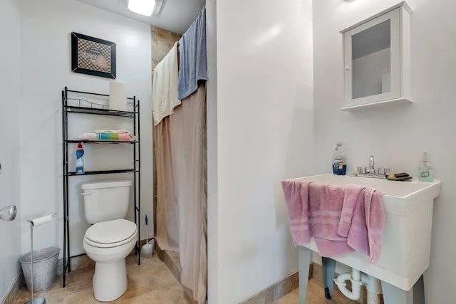 bathroom featuring tile patterned floors, toilet, a shower with curtain, and baseboards