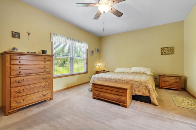 bedroom with ceiling fan, light colored carpet, and baseboards