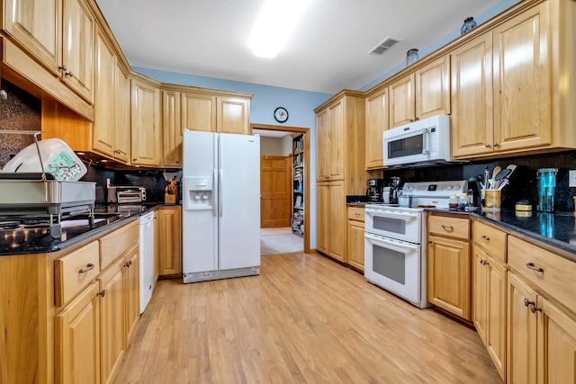 kitchen featuring light wood-style floors, light brown cabinets, white appliances, and visible vents