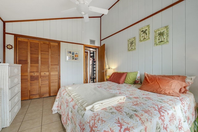 bedroom featuring ceiling fan, vaulted ceiling, a closet, and light tile patterned floors