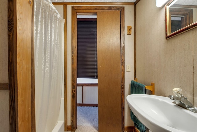 bathroom with shower / tub combo with curtain and sink