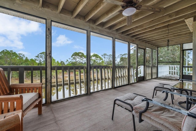 sunroom / solarium featuring a water view and ceiling fan