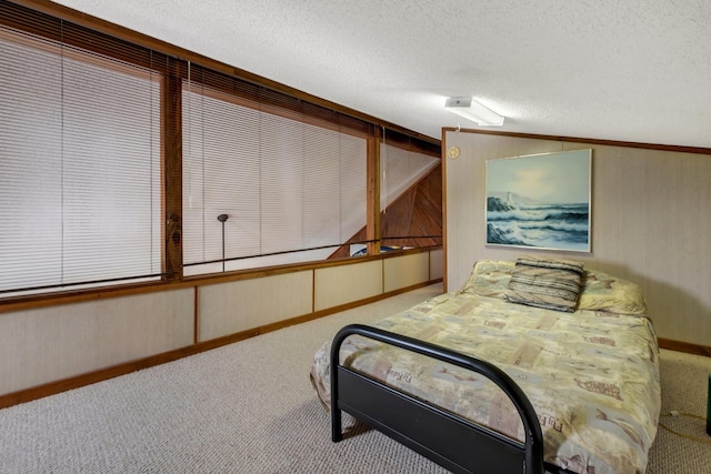 carpeted bedroom with vaulted ceiling, wooden walls, and a textured ceiling