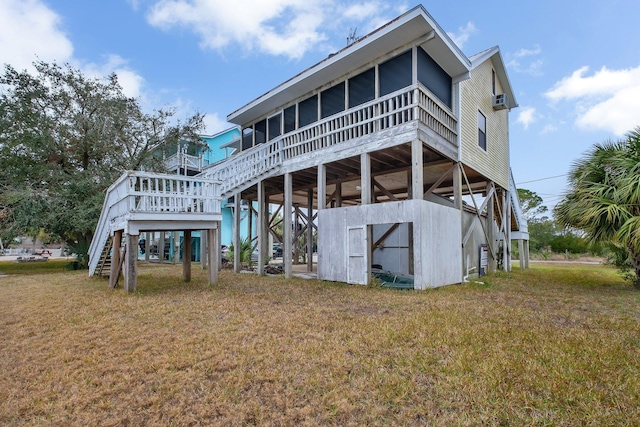 back of property with a sunroom and a lawn