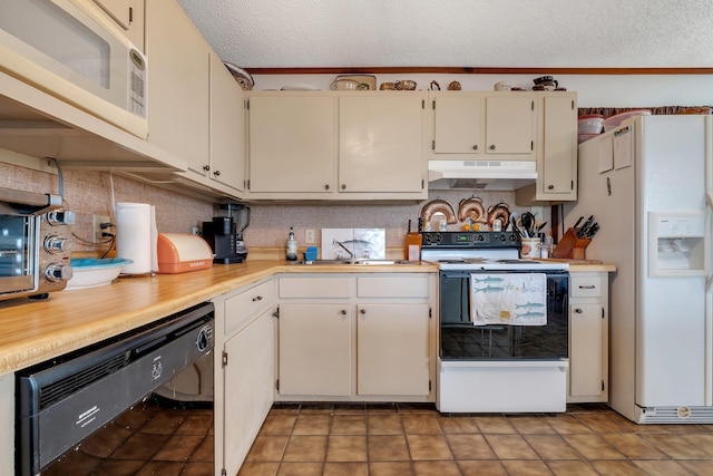 kitchen featuring sink, light tile patterned floors, a textured ceiling, and white appliances