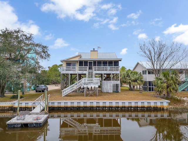 back of house featuring a water view and a sunroom