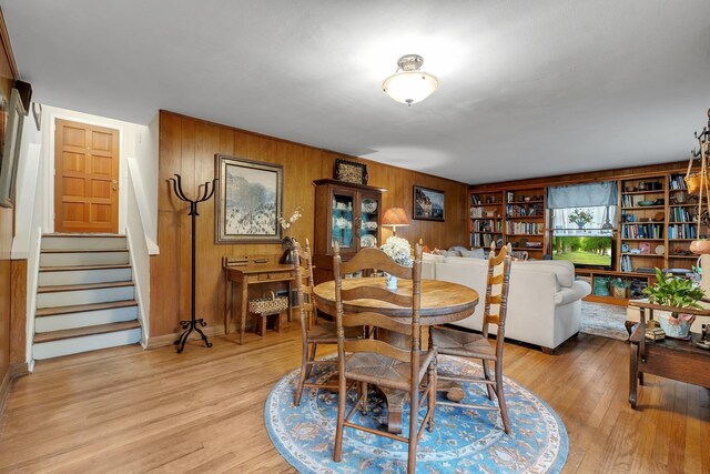 2003 Holly St, Tallahassee, FL 32303 - dining area featuring wood walls, light wood-style flooring, and stairs
