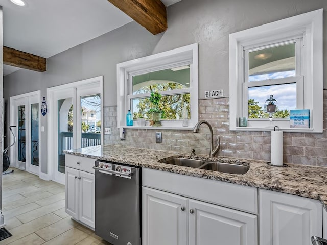 kitchen with beam ceiling, a sink, white cabinetry, stainless steel dishwasher, and decorative backsplash