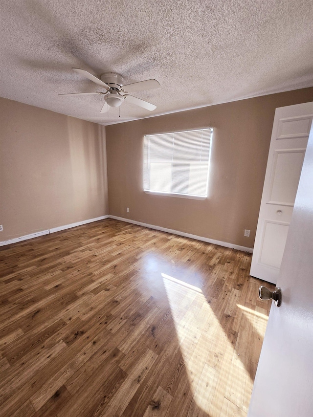 spare room with hardwood / wood-style floors, a textured ceiling, and ceiling fan