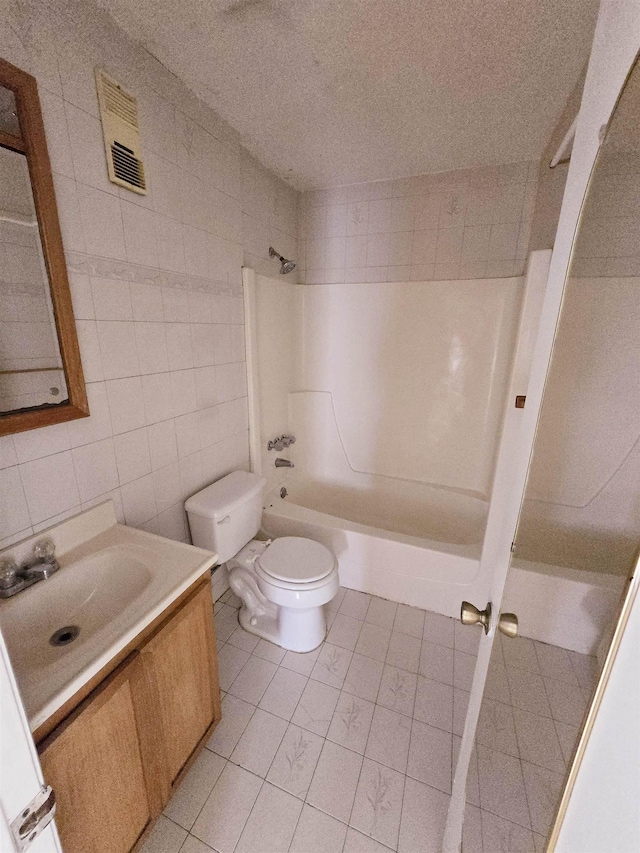 full bathroom with shower / tub combination, tile walls, vanity, and toilet